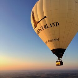 Ein Heißluftballon mit dem Schriftzug „Lembergerland“ schwebt bei Sonnenuntergang über der Hügellandschaft | © Lembergerland Kellerei Rosswag eG
