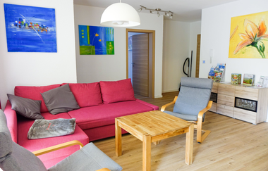 Wohnzimmer mit roter Couch und einem Tisch, dazu zwei grau gepolsterte Stühle | © Neckar-Zaber-Tourismus e.V.