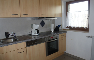 Kleine Küche der Ferienwohnung mit Spüle, Ofen und Kaffeemaschine | © E. Hügler