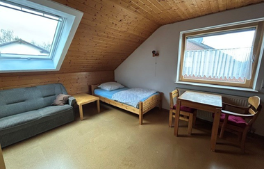 Blick in ein Schlafzimmer mit Couch, Einzelbett und einem kleinen Tisch | © Neckar-Zaber-Tourismus e.V.