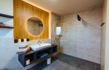 Aufnahme des Badezimmers: Waschbecken mit Spiegel, schwarzes Regal darunter | © Neckar-Zaber-Tourismus e.V.