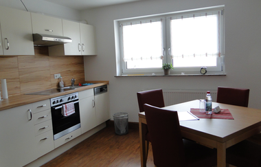 Küche mit weißen Schränken und Schubladen und einem Tisch mit vier Stühlen | © Neckar-Zaber-Tourismus e.V.