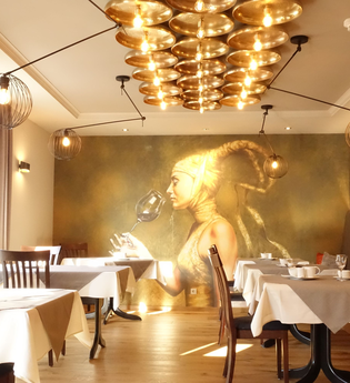 Frühstücksraum mit goldenem Bild von einer Frau im Hintergrund. Rechts gibt es eine Sitzbank mit Kissen und links stehen die Tische am Fenster. | © Neckar-Zaber-Tourismus e.V.