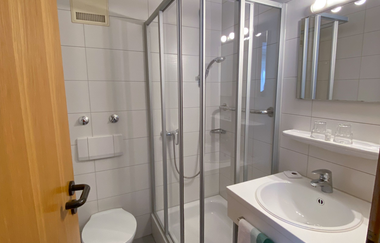 Aufnahme vom Eingang des Badezimmers aus mit Blick auf Waschbecken (mit Spiegel), Dusche und Toilette. | © Neckar-Zaber-Tourismus e.V.