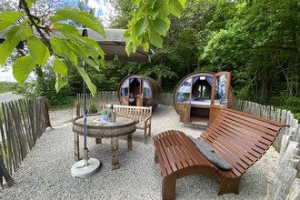 Zwei Weinfässer mit einem Außenbereich. Auf dem Kiesbett stehen Sitzbänke und Tische, der Bereich ist eingezäunt. | © Jakobshof Lehr