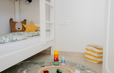 Blick in ein Kinderzimmer mit weißem Stockbett und Spielsachen. | © Weingut Becker, Malsch