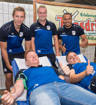 Zwei Männer liegen auf Liegen und spenden Blut, während drei weitere Männer daneben stehen und Daumen hoch zeigen. | © Erlebnispark Tripsdrill