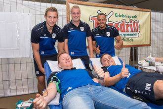 Zwei Männer liegen auf Liegen und spenden Blut, während drei weitere Männer daneben stehen und Daumen hoch zeigen. | © Erlebnispark Tripsdrill