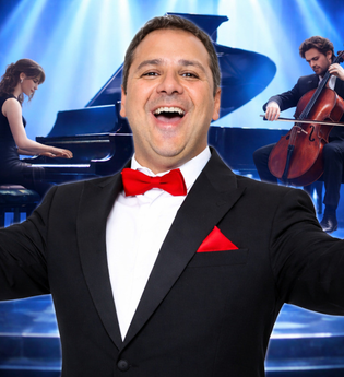 Ein Mann im Smoking steht vor einem Flügel auf einer Bühne mit dem Schriftzug 'Andrea Bocelli Tribute'. | © Andrea Bocelli Tribute