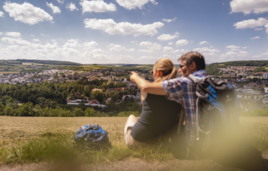 Außerhalb der Stadt sitzt ein Paar und genießt die Aussicht auf Bad Mergentheim. | © Philipp Reinhard