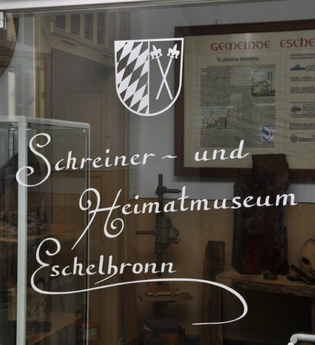 Weißer Schriftzug Schreiner- und Heimatmuseum auf Glas