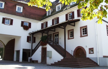Weißes Rathausgebäude von Helmstadt Bargen mit Treppenaufgang und gepflastertem Innenhof | © Gemeinde Helmstadt-Bargen