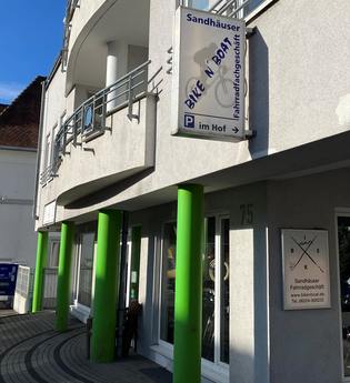 Außenansicht des Fahrradgeschäfts mit grünen Säulen