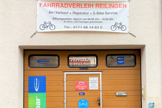 Eingangstor zum Fahrradverleih mit verschiedenen Informationsbannern