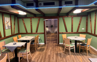 Innenbereich mit mehreren Tischen und passenden Stühlen dazu | © NZT