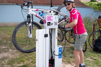 Radfahrerin an einer Rad Service Station mit einem aufgehängten Rad, um die Reifen aufzupumpen. | © Landratsamt Rhein-Neckar-Kreis