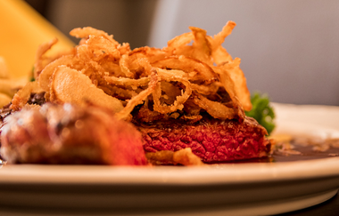 Nahaufnahme eines Steaks mit Röstzwiebeln auf einem Teller. | © Restaurant Café Hirsch