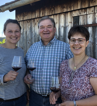 Familie Blatt mit lachenden Gesichtern vor einer Weinberghütte | © Weingut Matthias Blatt