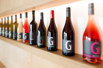 Verschiedene Weinflaschen des Weingut Gmelin auf einem Holzregal