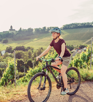 Radfahrerin am Schöllkopf in Brackenheim am Württemberger Weinradweg | © Touristikgemeinschaft HeilbronnerLand e.V.