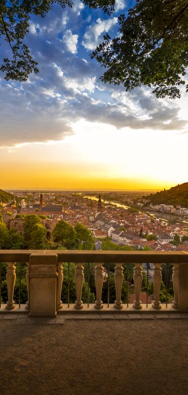 Panorama der Heidelberger Altstadt mit dem Heidelberger Schloss auf einem Hügel, umgeben von grüner Landschaft bei Sonnenuntergang | © Heidelberg Marketing GmbH, Foto Tobias Schwerdt
