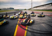 Mehrere Personen sitzen in gelb-schwarzen Karts auf einer Rennstrecke mit Tribünen im Hintergrund | © Hockenheim-Ring GmbH