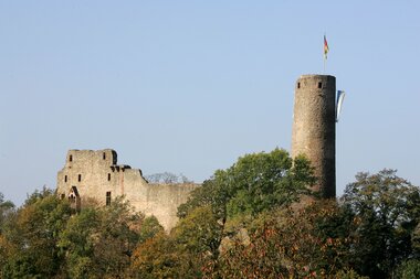 Burgruine Windeck in Weinheim mit rundem Bergfried und teilweise erhaltenen Mauern, umgeben von Bäumen unter klarem Himmel | © Landratsamt Rhein-Neckar-Kreis