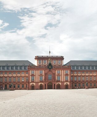 Weitläufiger Innenhof des barocken Mannheimer Schlosses mit symmetrischen Gebäudeflügeln und Bäumen entlang der Fassaden. | © Medienarchiv Rhein-Neckar-Kreis